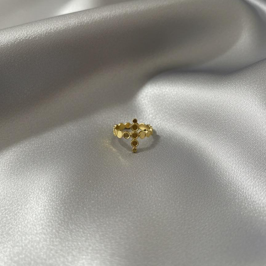 Gold ring with small stones on a silver satin surface