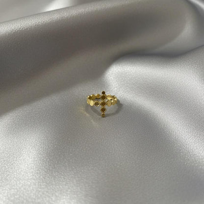 Gold ring with small stones on a silver satin surface