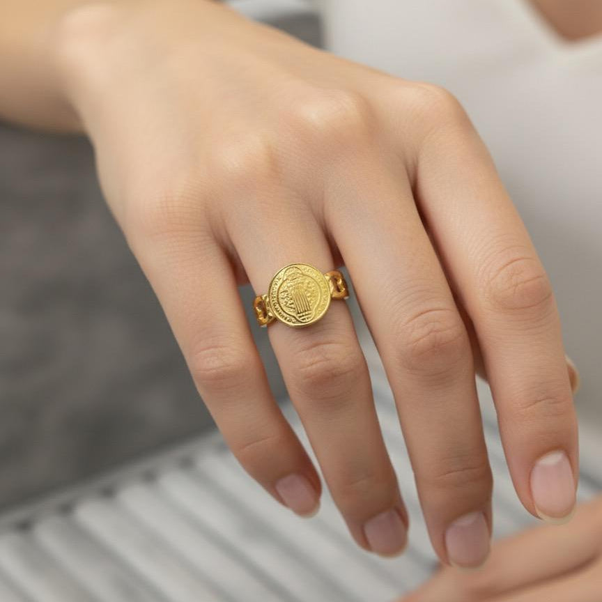 Gold ring on a person's finger with a blurred background
