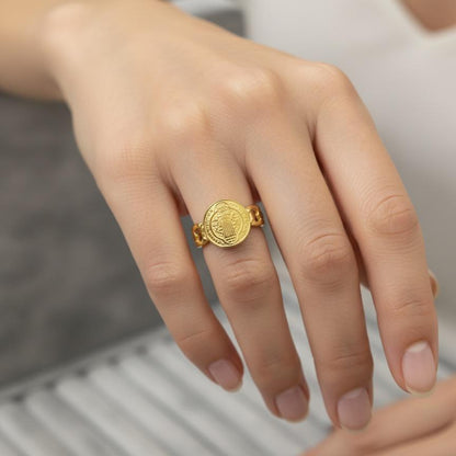 Gold ring on a person's finger with a blurred background
